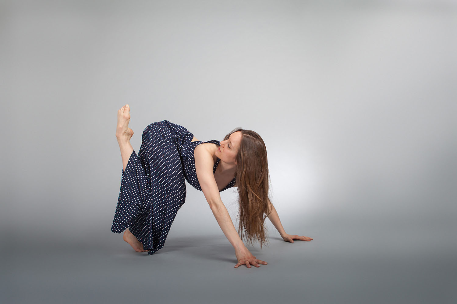Lea Hladka, eine schöne Tänzerin, ist in eine Fotostudio von mir fotografiert worden, Frühling 2016. Sie ist mit beiden Hände am Boden, ein Fuß am Boden und der andere Fuß gebogen in dert Luft, sie schut nach hinter für diese Fuß.